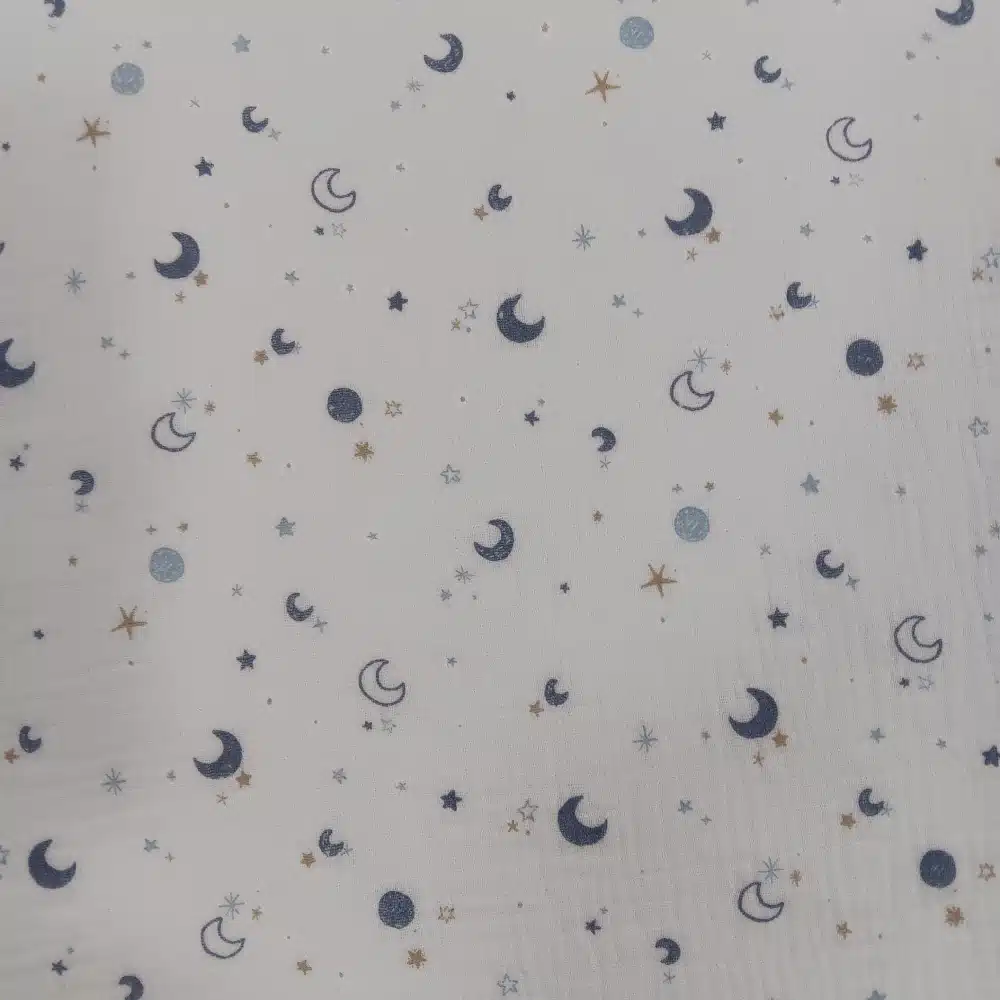 Muselina de algodón estampada con lunas y estrellas en tonos azules sobre fondo claro