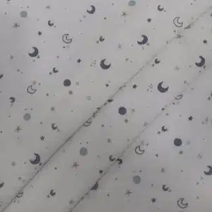 Muselina de algodón estampada con lunas y estrellas en tonos azules sobre fondo claro