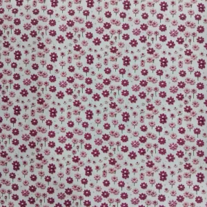 Tela de algodón estampada 3D con pequeñas flores en tonos rosa sobre fondo blanco.