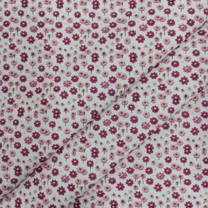 Tela de algodón estampada 3D con pequeñas flores en tonos rosa sobre fondo blanco.