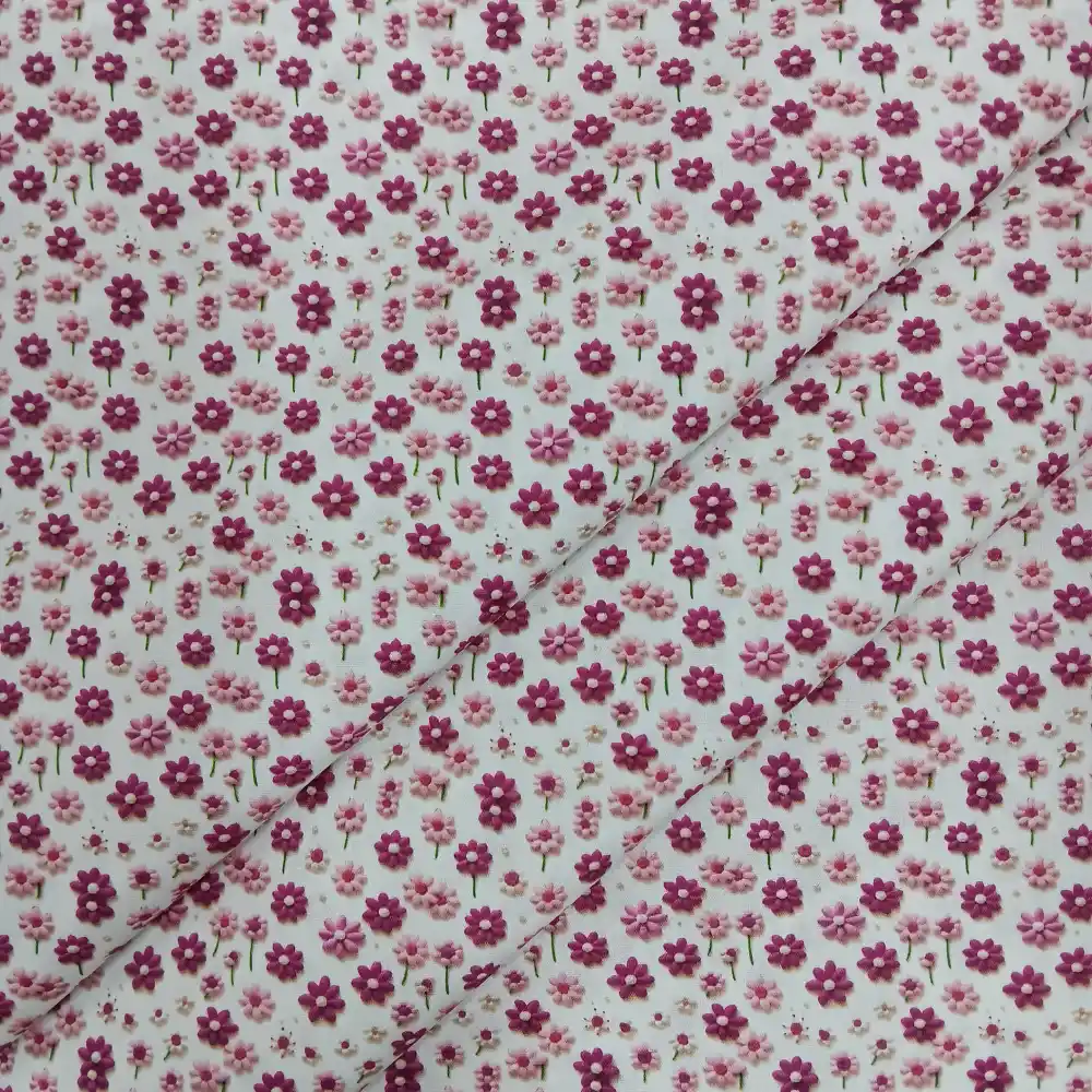 Tela de algodón estampada 3D con pequeñas flores en tonos rosa sobre fondo blanco.