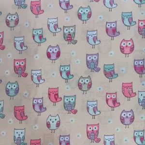 Tela de algodón con estampado de búhos en tonos rosa, verde y lila sobre fondo beige, ideal para proyectos infantiles.