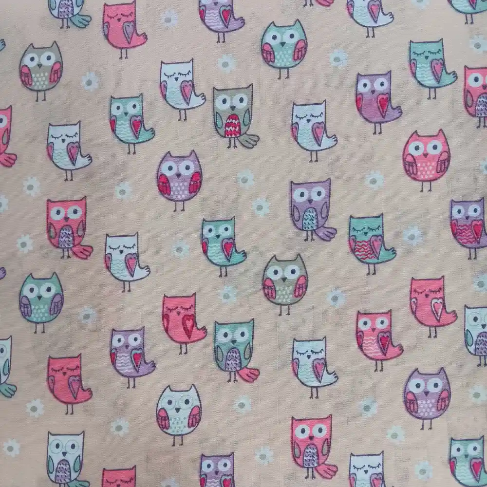 Tela de algodón con estampado de búhos en tonos rosa, verde y lila sobre fondo beige, ideal para proyectos infantiles.