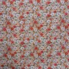 Tela de algodón con estampado floral de pequeñas flores naranjas