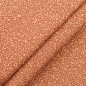 Tela de algodón rústico naranja con flores pequeñas y textura natural