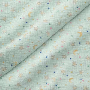 Tela de muselina de algodón verde menta con estampado de estrellas y lunas