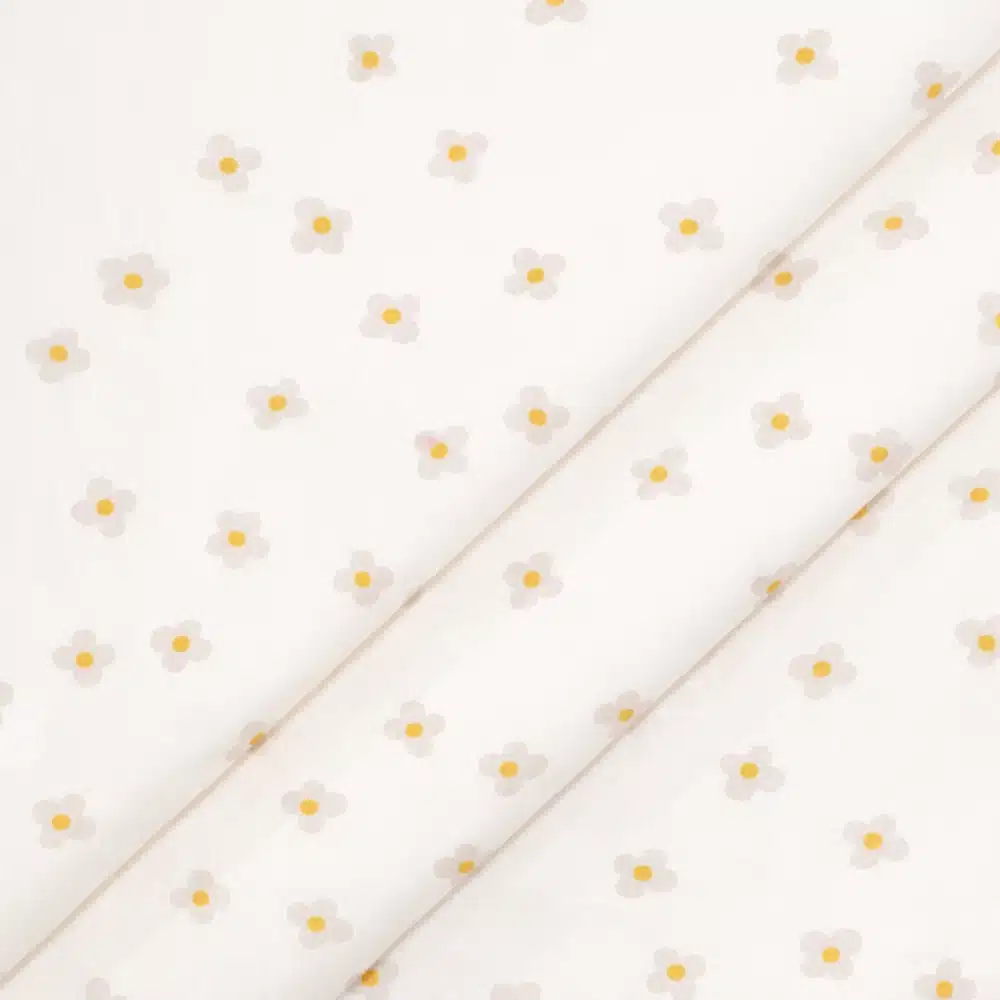 Tela de algodón flores beige con centro amarillo sobre fondo claro y estampado delicado.