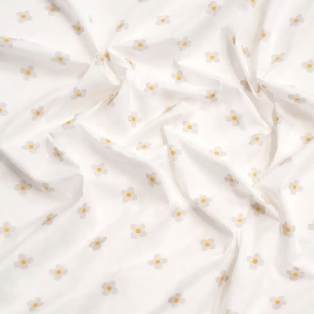 Tela de algodón flores beige con centro amarillo sobre fondo claro y estampado delicado.