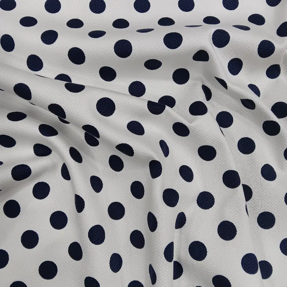 Tela piqué blanca con lunares azules en estampado clásico y textura gofrada