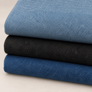Tela de jeans en tres colores, azul claro, negro y azul, presentada en telas dobladas y apiladas.