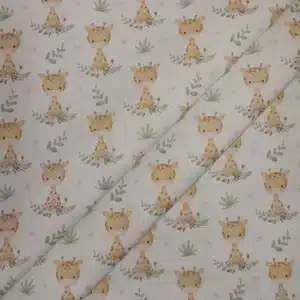 Tela de algodón estampada con jirafas sobre fondo claro, acompañadas de pequeñas hojas, ramas y motivos vegetales en tonos suaves.