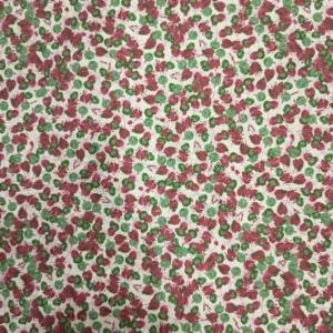 Tela de algodón con estampado de pequeñas flores verdes y burdeos distribuidas sobre un fondo blanco roto, con motivos florales repetidos por toda la superficie.