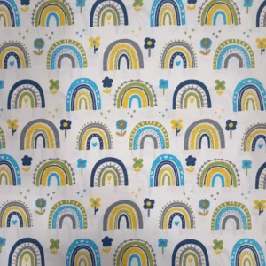 Tela de algodón infantil estampada con arcoíris azules, amarillos, verdes y grises, acompañados de pequeñas flores y corazones sobre fondo claro.