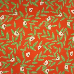 Tela de algodón naranja con flores beige de centros oscuros y ramas de hojas verdes alargadas, distribuidas sobre un fondo naranja intenso.