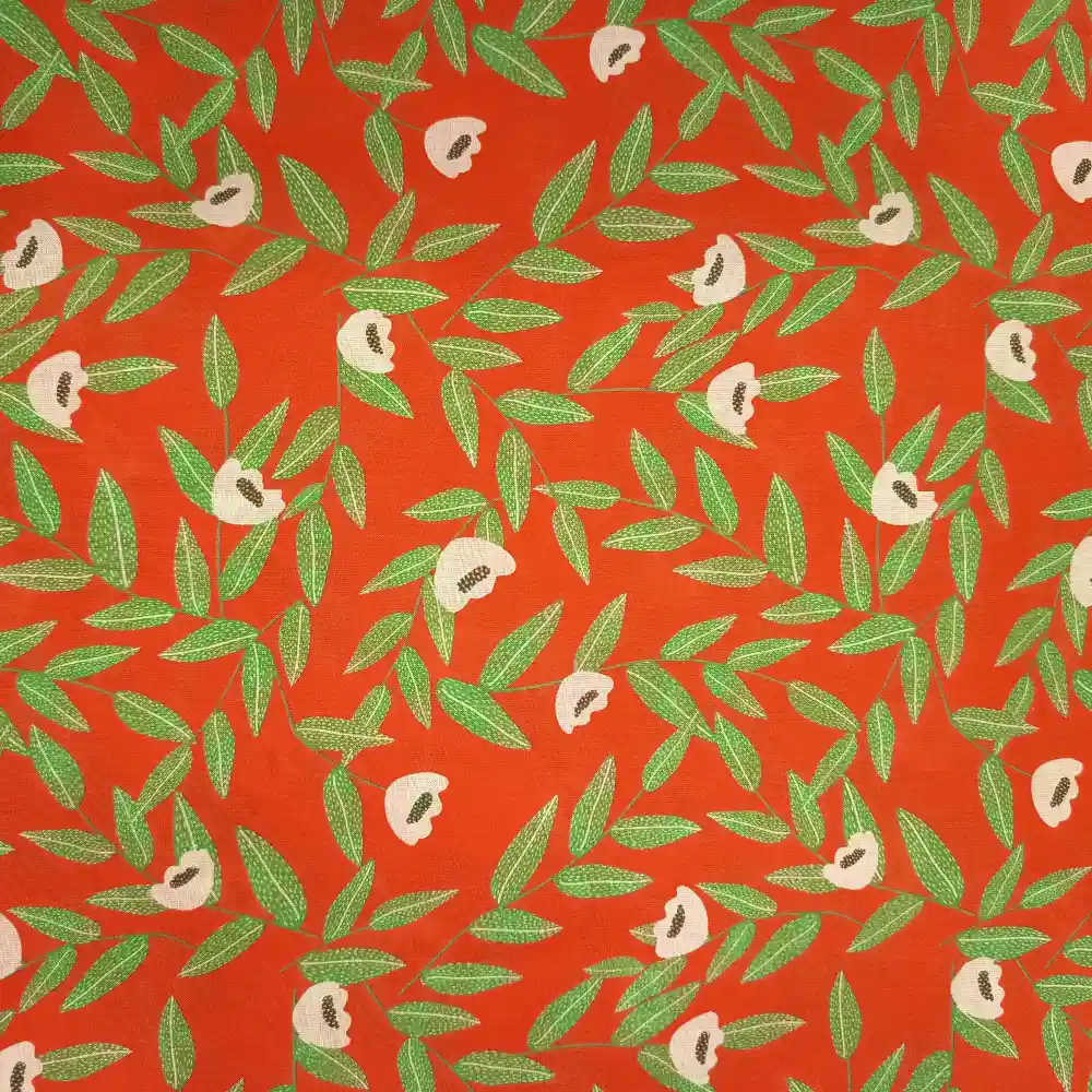 Tela de algodón naranja con flores beige de centros oscuros y ramas de hojas verdes alargadas, distribuidas sobre un fondo naranja intenso.