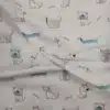 Tela de algodón estampada con perros divertidos de diferentes diseños y pequeños huesos en tonos suaves sobre fondo claro.