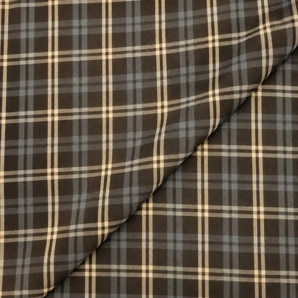 Tela cuadro grande marrón con estampado de líneas beige y gris azulado formando cuadros grandes.
