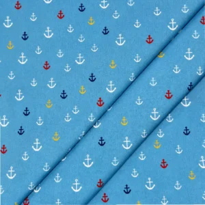 Tela de algodón azul con pequeñas anclas estampadas de diferentes tamaños en blanco, rojo, amarillo y azul marino, distribuidas por toda la superficie.