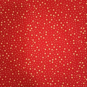Tela de algodón navideña roja con numerosas estrellas doradas de diferentes tamaños distribuidas por toda la superficie.