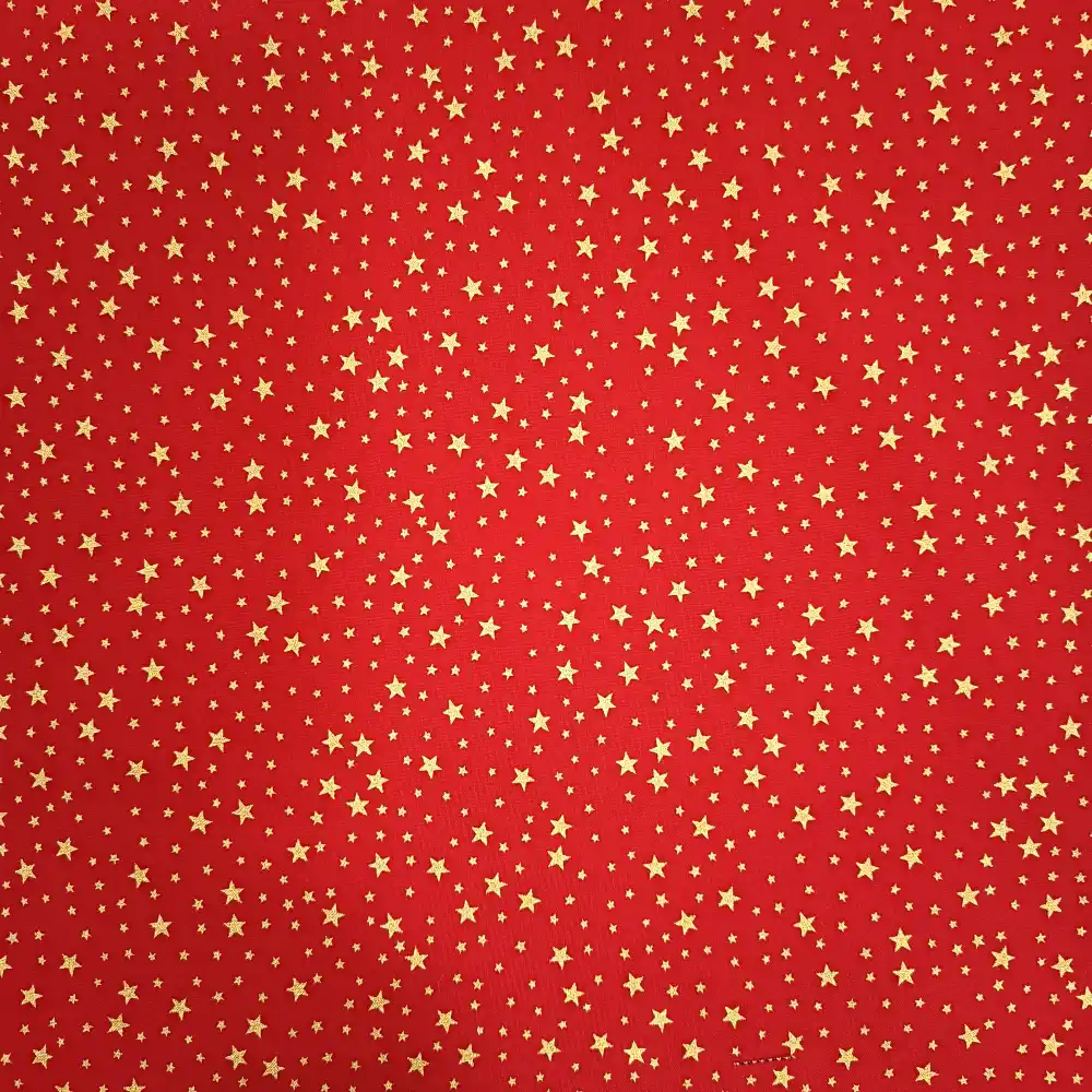 Tela de algodón navideña roja con numerosas estrellas doradas de diferentes tamaños distribuidas por toda la superficie.