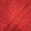 Tela de algodón navideña roja con numerosas estrellas doradas de diferentes tamaños distribuidas por toda la superficie.