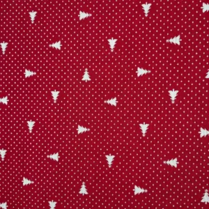 Detalle de tela jacquard roja con pequeños árboles de Navidad blancos orientados en distintas direcciones y diminutos motivos blancos repartidos por toda la superficie.