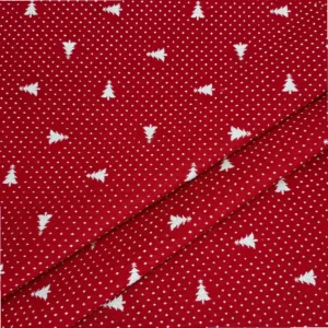 Detalle de tela jacquard roja con pequeños árboles de Navidad blancos orientados en distintas direcciones y diminutos motivos blancos repartidos por toda la superficie.