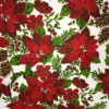 Tela de mantelería navideña blanca con flores de Pascua grandes en tonos rojos y burdeos, piñas marrones, bayas rojas y ramas verdes, dispuesta con pliegues diagonales.
