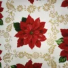 Tela de mantelería navideña blanca con una gran flor de Pascua roja, hojas verdes y filigranas doradas de flores, hojas y motivos curvos alrededor.