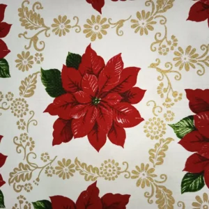Tela de mantelería navideña blanca con una gran flor de Pascua roja, hojas verdes y filigranas doradas de flores, hojas y motivos curvos alrededor.
